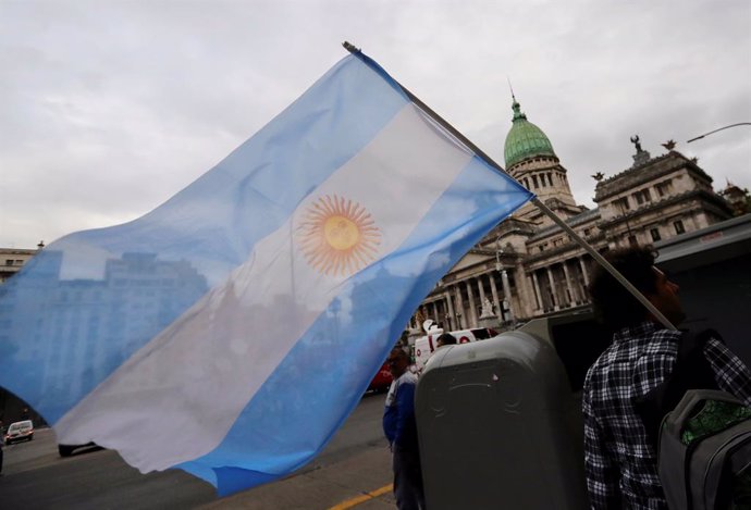 A man waves an Argentine national flag during a protest against a cost increase