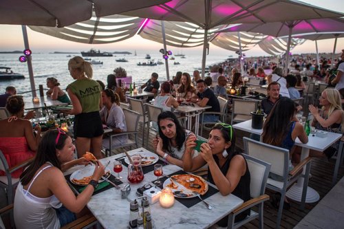 Turistas en un restaurante a pie de playa