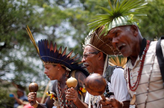 Indigenous people from various tribes dance as they wait to deliver a letter to