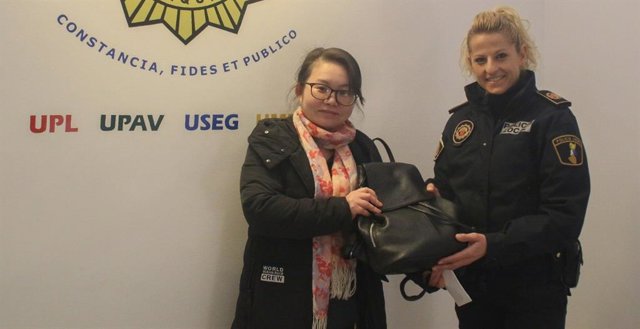 La propietaria del bolso perdido con una agente de la Policía Local