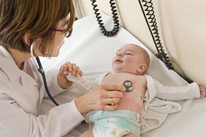 Pediatra auscultando a un paciente.