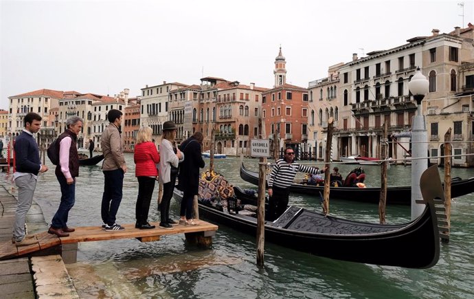 Turistas suben a una góndola en Venecia