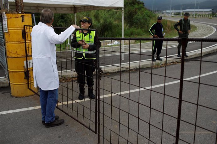 A Venezuelan doctor speaks with a Colombian police officer during a gathering at