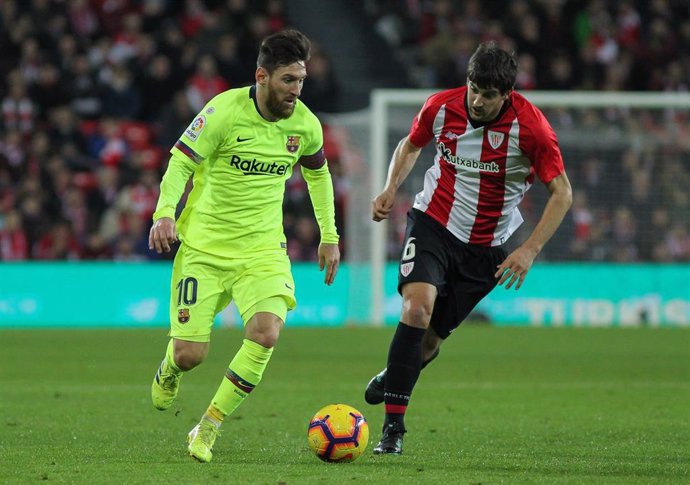 Messi conduce el balón perseguido por San José en el Athletic-FC Barcelona