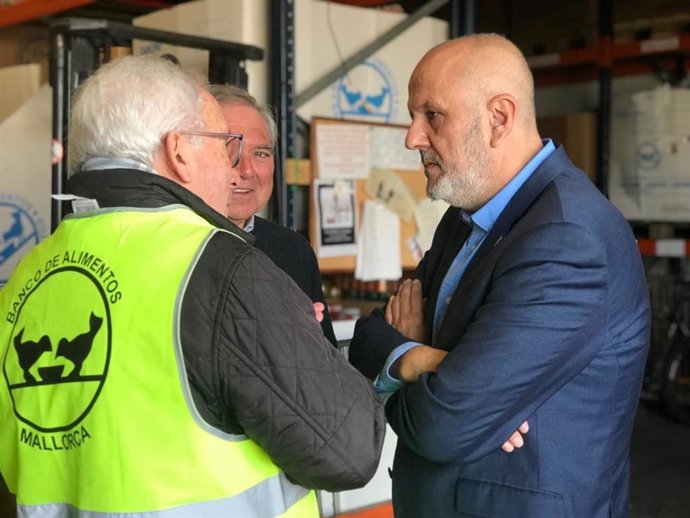 El president del Consell, Miquel Ensenyat, amb treballadors del Banc d'Aliments