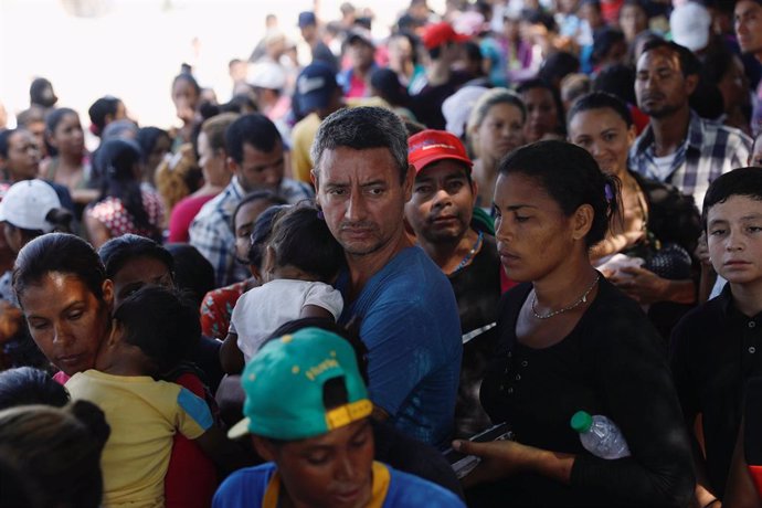 Venezuelans line up as they wait for a free lunch at the "Divina Providencia" mi