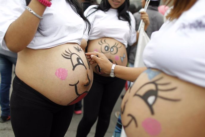 Pregnant women paint their bellies before an event to celebrate "Healthy Materni