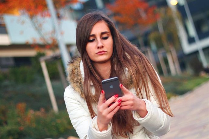 Adolescente, mujer usando su teléfono móvil, smartphone