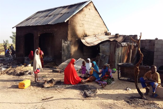 Personas junto a una casa destruida presuntamente por Boko Haram en Nigeria