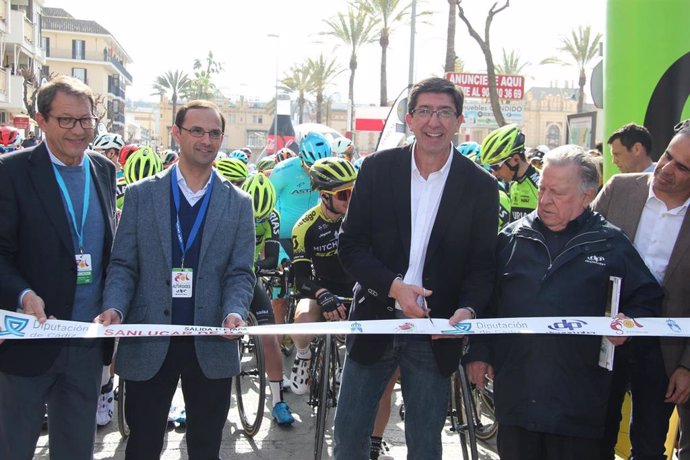 Juan Marín cortando la cinta de la salida de la Vuelta a Andalucía de ciclismo