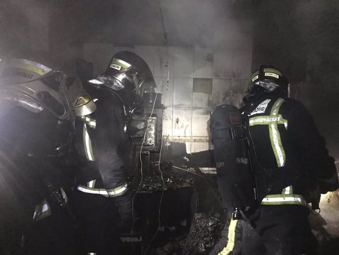 Bomberos de la Comunidad de Madrid trabajan en el incendio de una vivienda