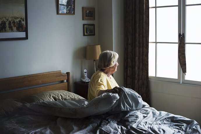 Anciana, mayor, mujer levantándose de la cama, madrugar, canas, sedentarismo