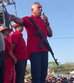 Un diputado chavista ofrece un discurso con un fusil colgado al cuello