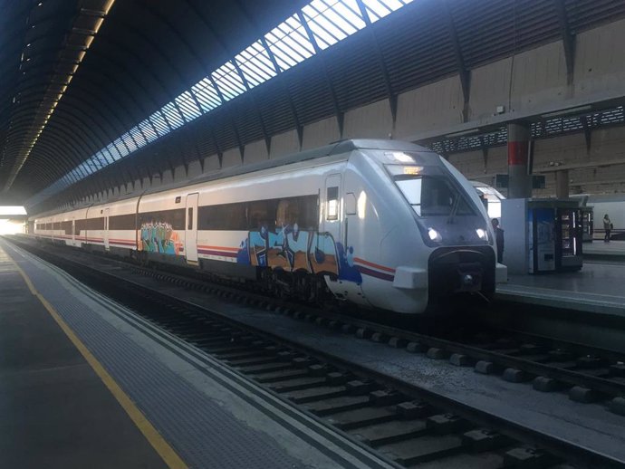Tren media distancia de Renfe con pintadas en la estación Sevilla Santa Justa