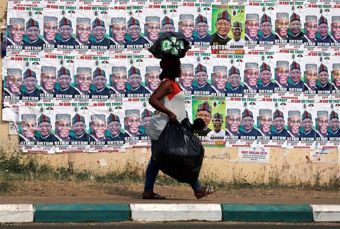 Una mujer de Nigeria camina junto a carteles electorales del opositor Atiku Abub
