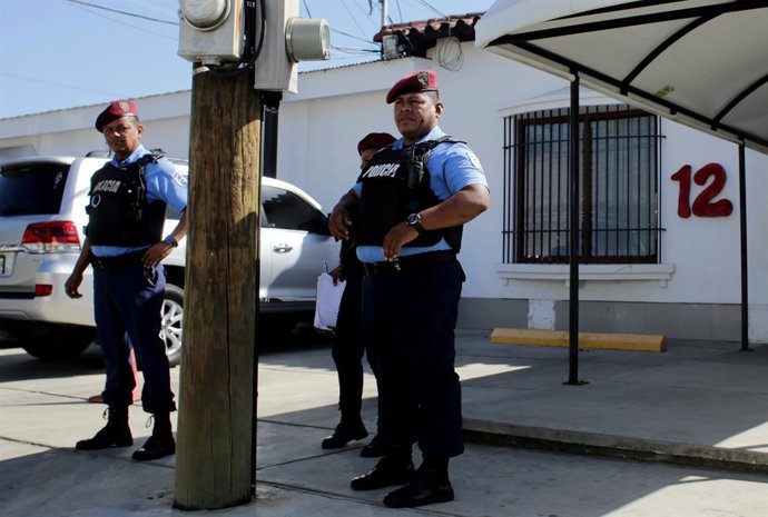 Police officers stand guard at the entrance of  Channel 12 TV station building i