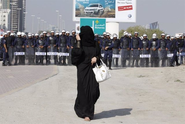 Mujer saudí frente a un cordón policial