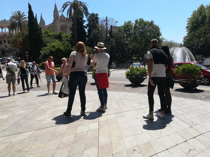Turistes prenent-se fotos en el Passeig del Born amb la catedral al fons
