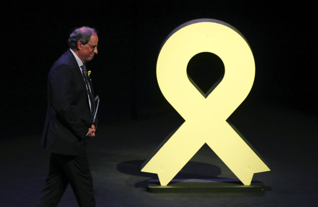 Quim Torra pasa por delante de un lazo amarillo 