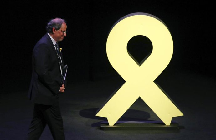 Quim Torra pasa por delante de un lazo amarillo 