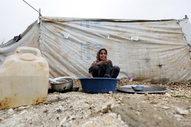Iman, de 11 años, lava la ropa en un campamento de desplazados internos en Siria