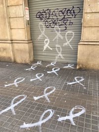 La sede del PSC de Barcelona amanece con lazos blancos pintados en el suelo y en su persiana