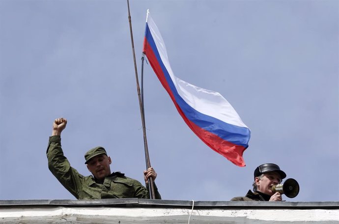 Soldados prorrusos agitan una bandera Rusa en un cuartel en Crimea