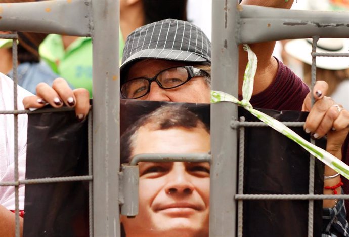 A supporter of Ecuador's former President Rafael Correa holds a photograph of Co