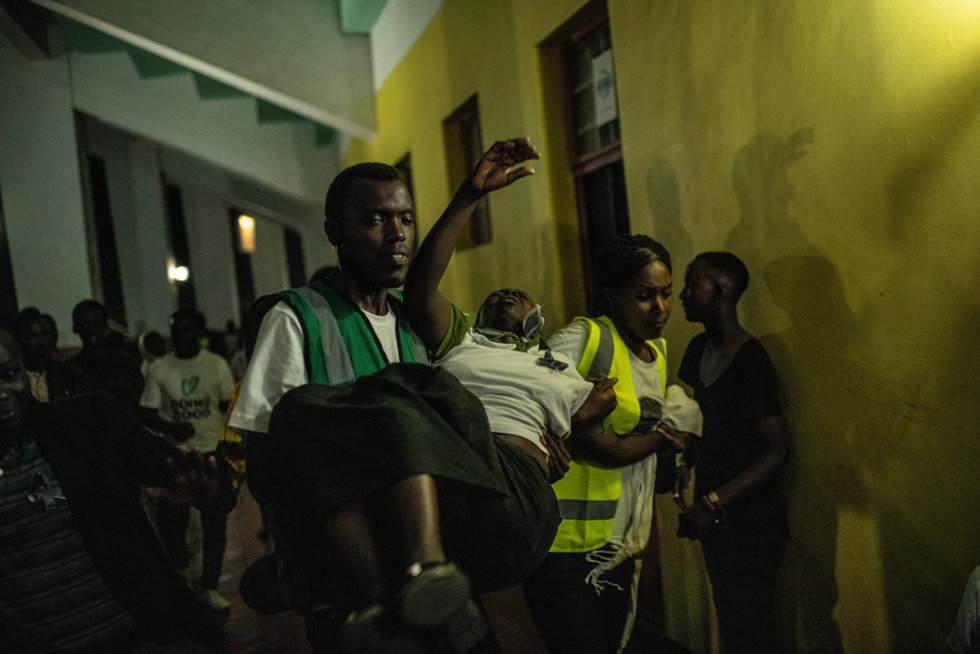 Una mujer golpeada por el dolor es llevada a cabo en una ceremonia de conmemoración a la luz de las velas del genocidio de 1994 el 7 de abril de 2019 en el estadio Amahoro en Kigali, Ruanda.