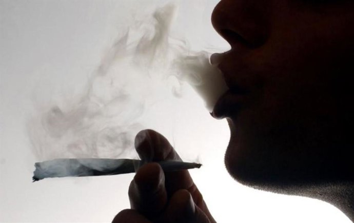 Un hombre fumando un porro de marihuana