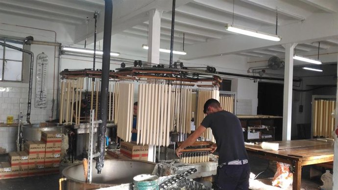Dos empleados trabajan en la fabricación de velas en la empresa Cera Bellido.