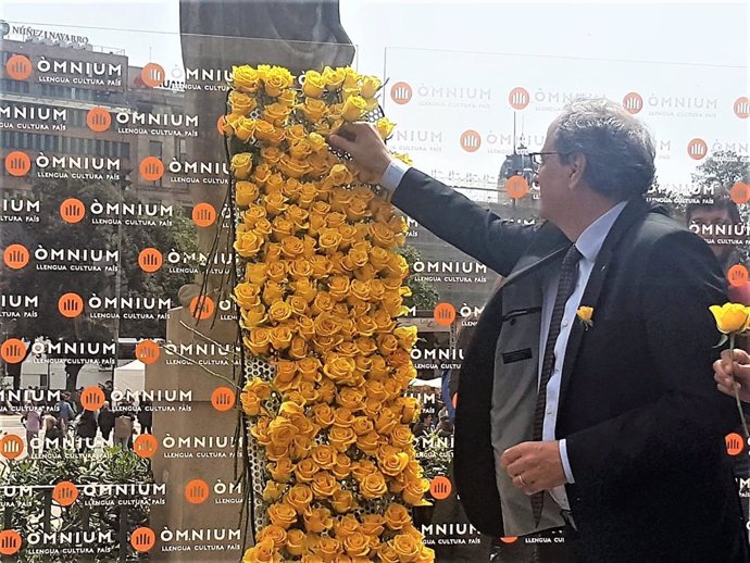 Sant Jordi.- Torra coloca una rosa amarilla en el Mural per la Llibertat de mnium