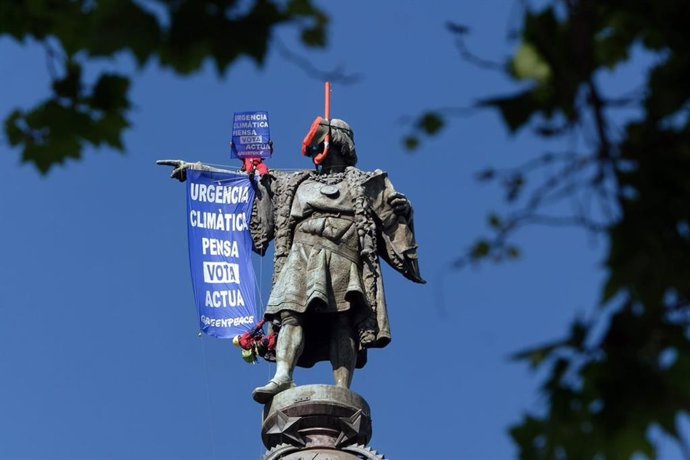 Greenpeace despliega un cartel por la "urgencia climática" en la estatua de Colón de Barcelona