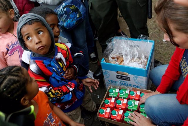Niños migrantes venezolanos esperan a recibir comida en Bogotá