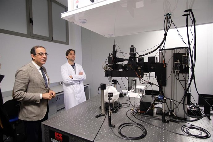 El rector de la US, Miguel Ángel Castro, observa un microscopio multifotón