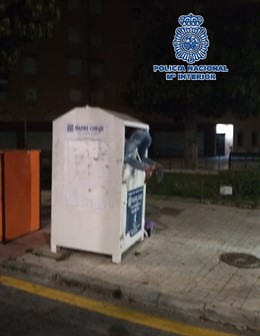 Málaga.- Sucesos.- Agentes de la Policía Nacional auxilian a una persona atrapada en un contenedor de ropa usada