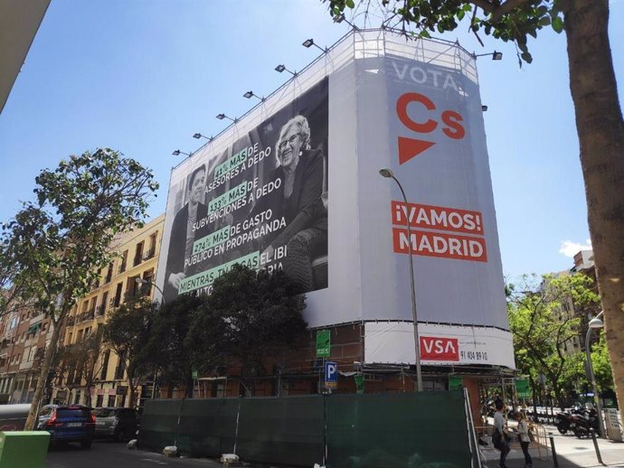 Cs coloca una lona con el cartel de campaña de Villacís en la calle Alcalá en la que arremete contra Carmena y Errejón