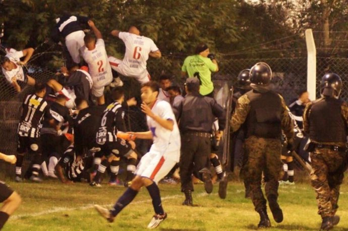 Una brutal pelea en un partido de fútbol obliga a los jugadores visitantes a salir por la valla del recinto