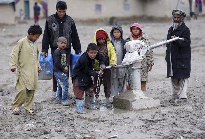 Niños beben agua de una fuente en Kabul