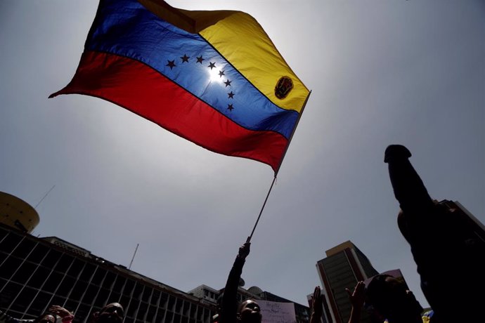 Manifestante con bandera de Venezuela en Caracas para apoyar a Maduro