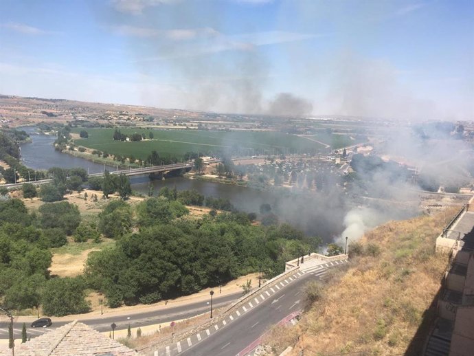 Incendios.- Bomberos de Toledo intentan sofocar un fuego cerca del Puente de Alcántara junto al Tajo