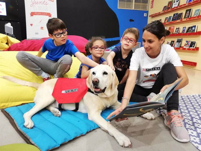 Un taller con perros de educación asistida fomenta la lectura en cien niños en la Feria del Libro de Madrid