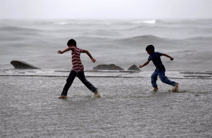 Niños corriendo por una playa de la India