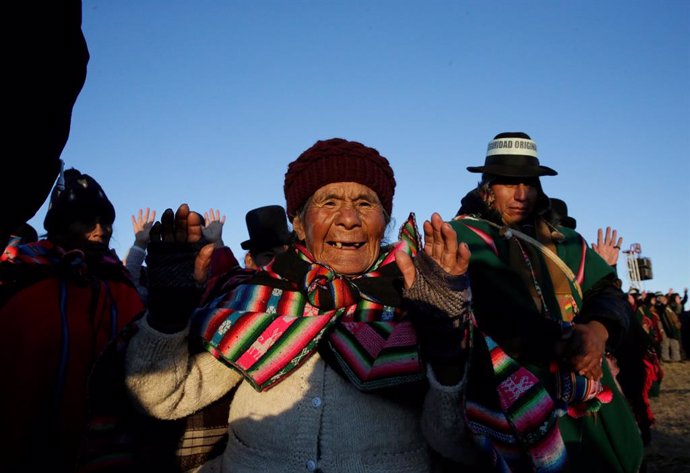 An Aymara woman raises her hands during a winter solstice ceremony that coincides with the Aymara Indian New Year in Tiwanaku
