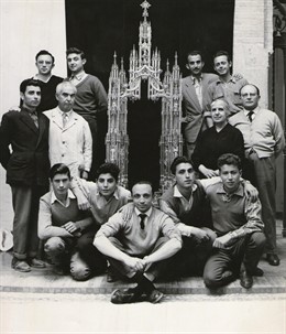 Rafael (centro) y Julio Martínez (arriba izda.) posan con trabajadores de su taller de orfebrería, a finales de los 50, con el portapaz que diseñaron y tallaron para el Altar Mayor de la Iglesia de San Hipolito