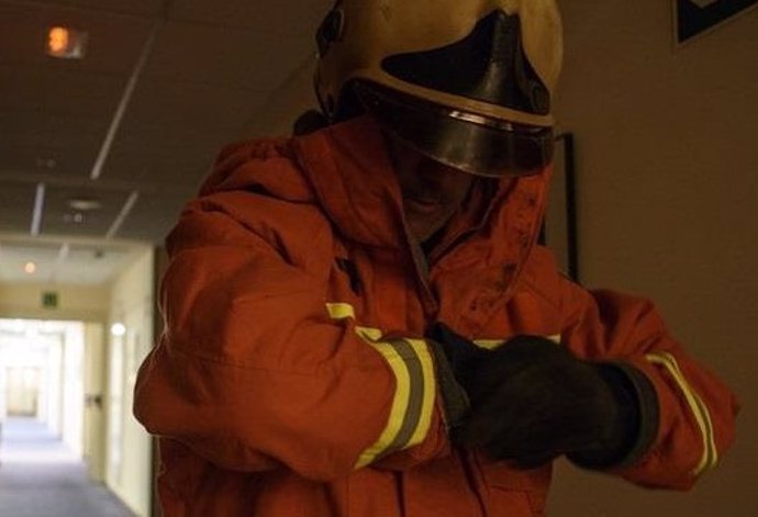 Imagen de archivo de un bombero poniéndose los guantes