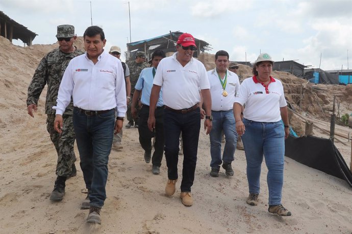 Peruvian ministers walk during a military operation to destroy illegal machinery and equipment used by wildcat miners in Madre de Dios