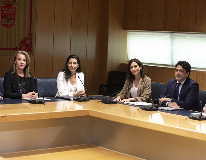 Les candidates de Vox i el PP, Rocío Monasterio i Isabel Díaz Ayuso, participen en una reunió acompanyats de membres dels seus respectius equips.