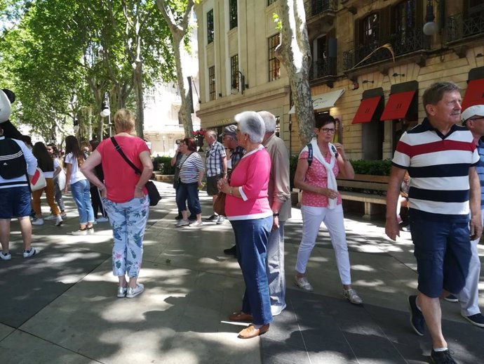 Turistas pasean por el Passeig del Born de Palma