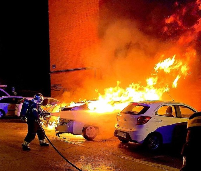 Bombero sofoca un incendio de un coche en la calle Islandia de la localidad de Fuenlabrada.
